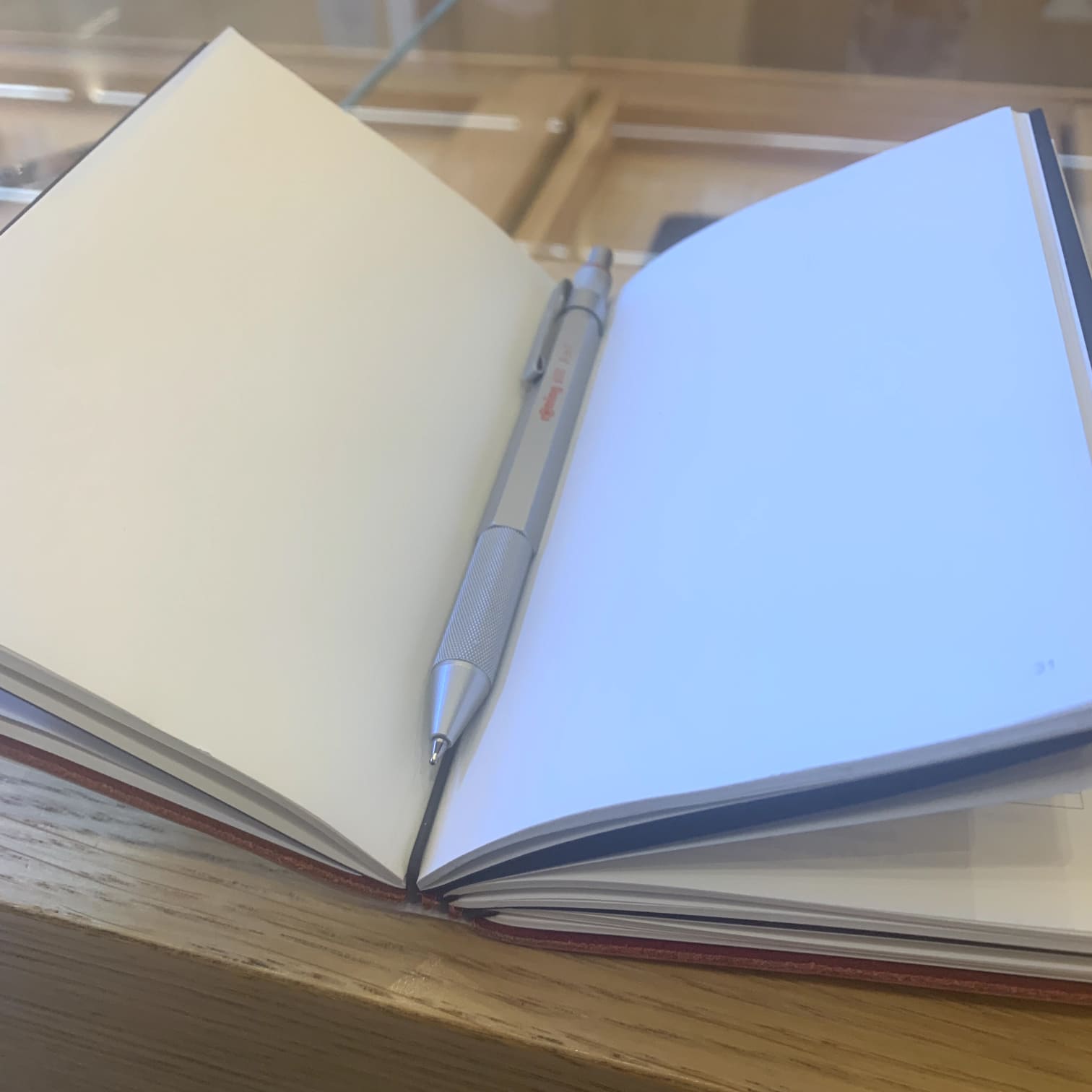 Fully open x17 rechargeable notebook on a white page with a Rotring 600 on the middle. Perfectly displays the benefits of the x17 biding system that allows you to use all the surface paper available.